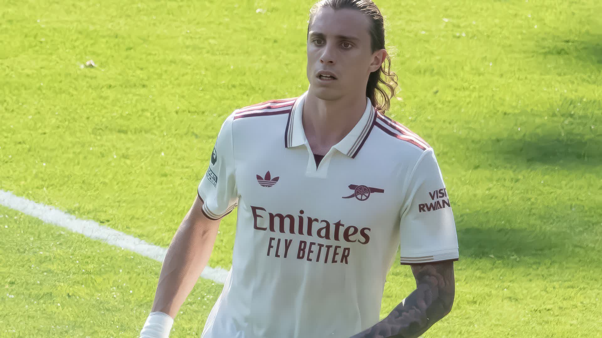 Riccardo Calafiori of Arsenal in a cream and burgundy kit on the pitch