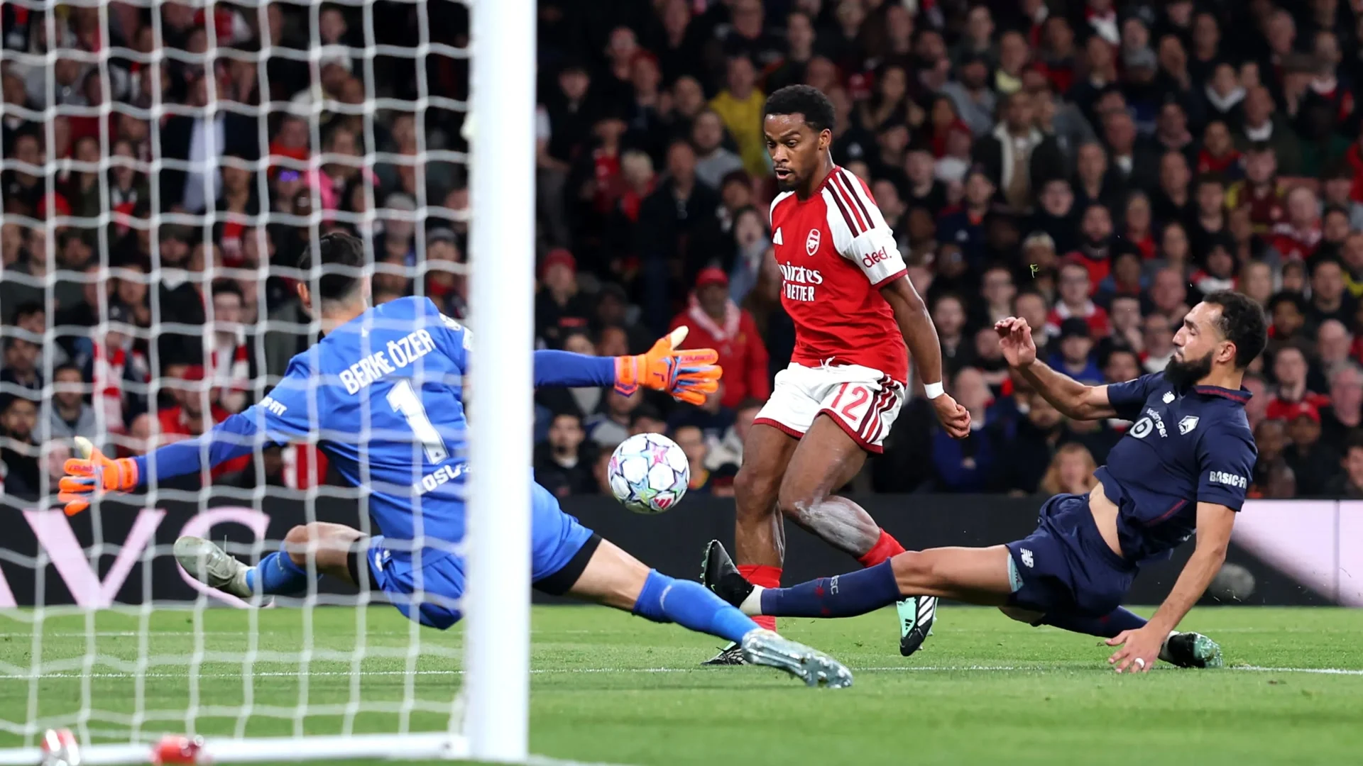 Jurriën Timber in Arsenal's red home kit lifts the ball past diving Lille goalkeeper Berke Özer to score at the Emirates Stadium. Photo: Arsenal.com match gallery