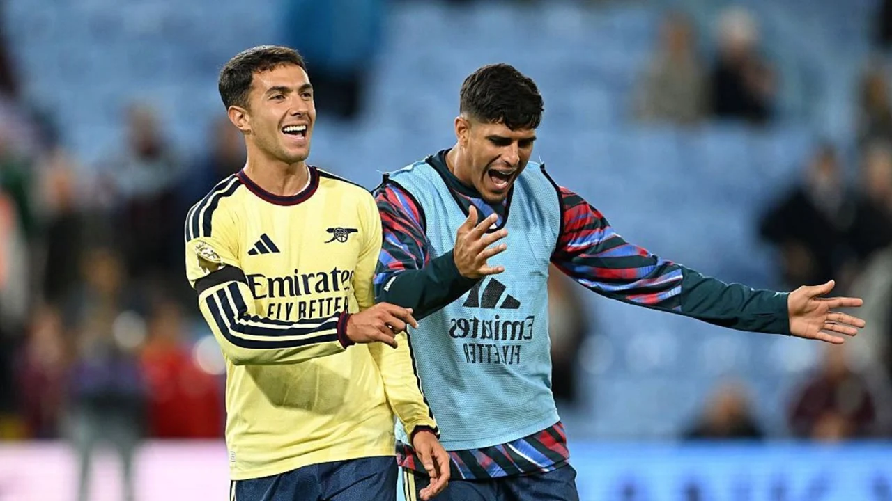 Martín Zubimendi in Arsenal's yellow away kit and Piero Hincapié in a light-blue training bib celebrate together on the pitch after an Arsenal match. Photo: Getty Images