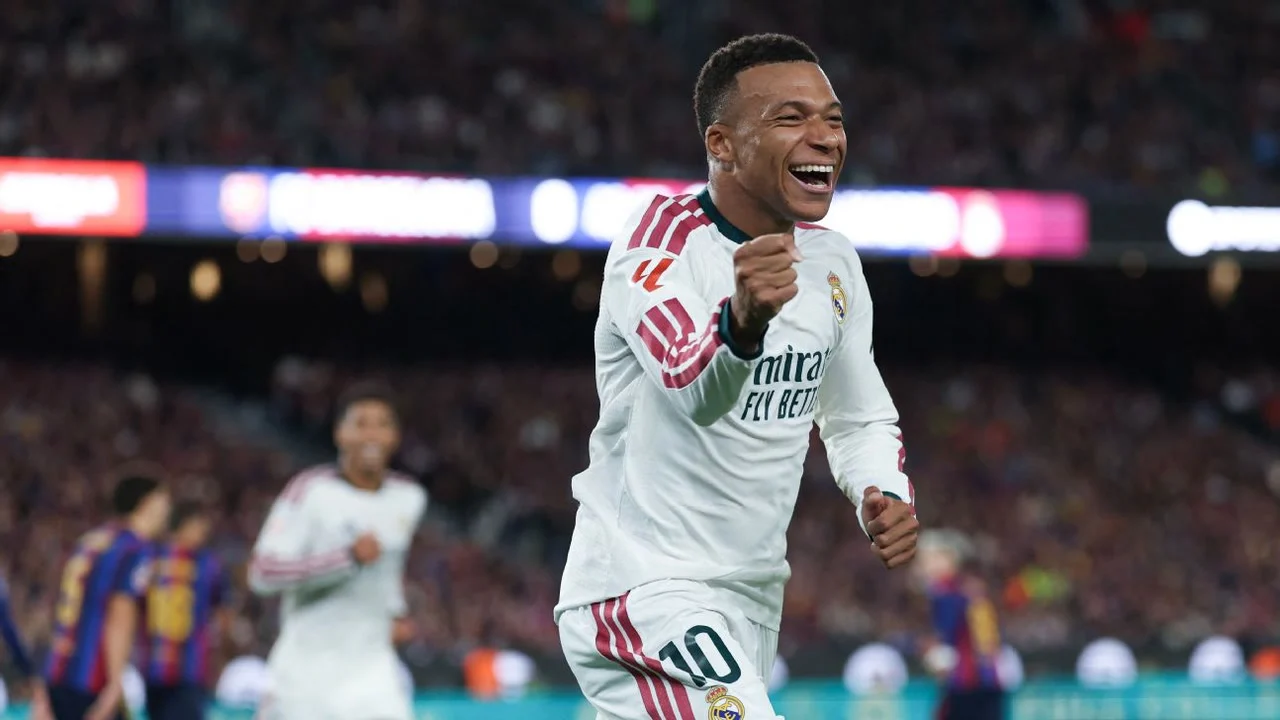 Kylian Mbappé celebrates with a clenched fist in Real Madrid's white away shirt during El Clásico against Barcelona at Spotify Camp Nou on 25 October 2026, with Barcelona players in blue and red in the background. Photo: Getty Images via ESPN