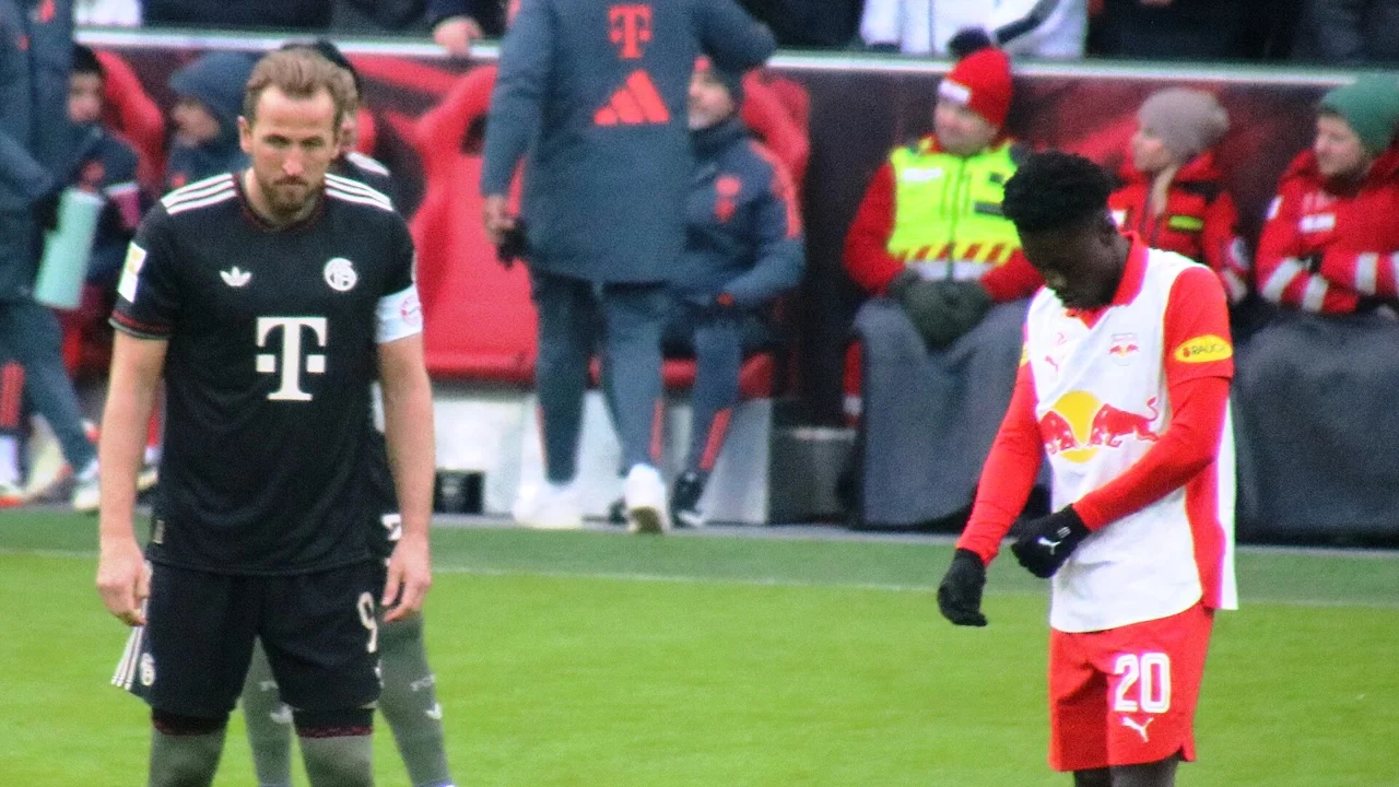 Harry Kane in Bayern Munich's black away kit with the captain's armband during Bayern's friendly at Red Bull Salzburg in January 2026, a Salzburg player in red and white alongside. Photo: Werner100359 / Wikimedia Commons (CC BY-SA 4.0)