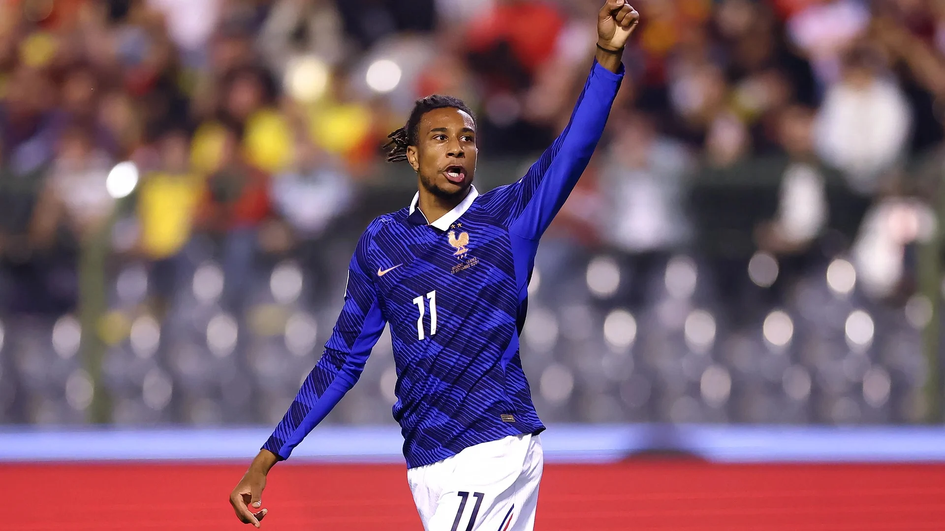 Michael Olise in a blue France number 11 jersey celebrating after scoring against Belgium in Brussels