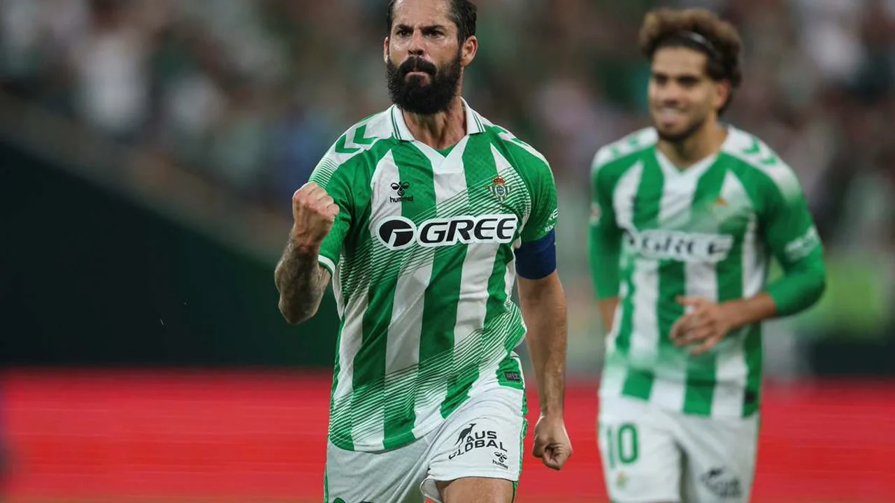 Isco celebrates in Real Betis' green-and-white striped kit after scoring against Osasuna at La Cartuja, with Abde Ezzalzouli approaching behind. Photo: Pozo / PRESSINPHOTO