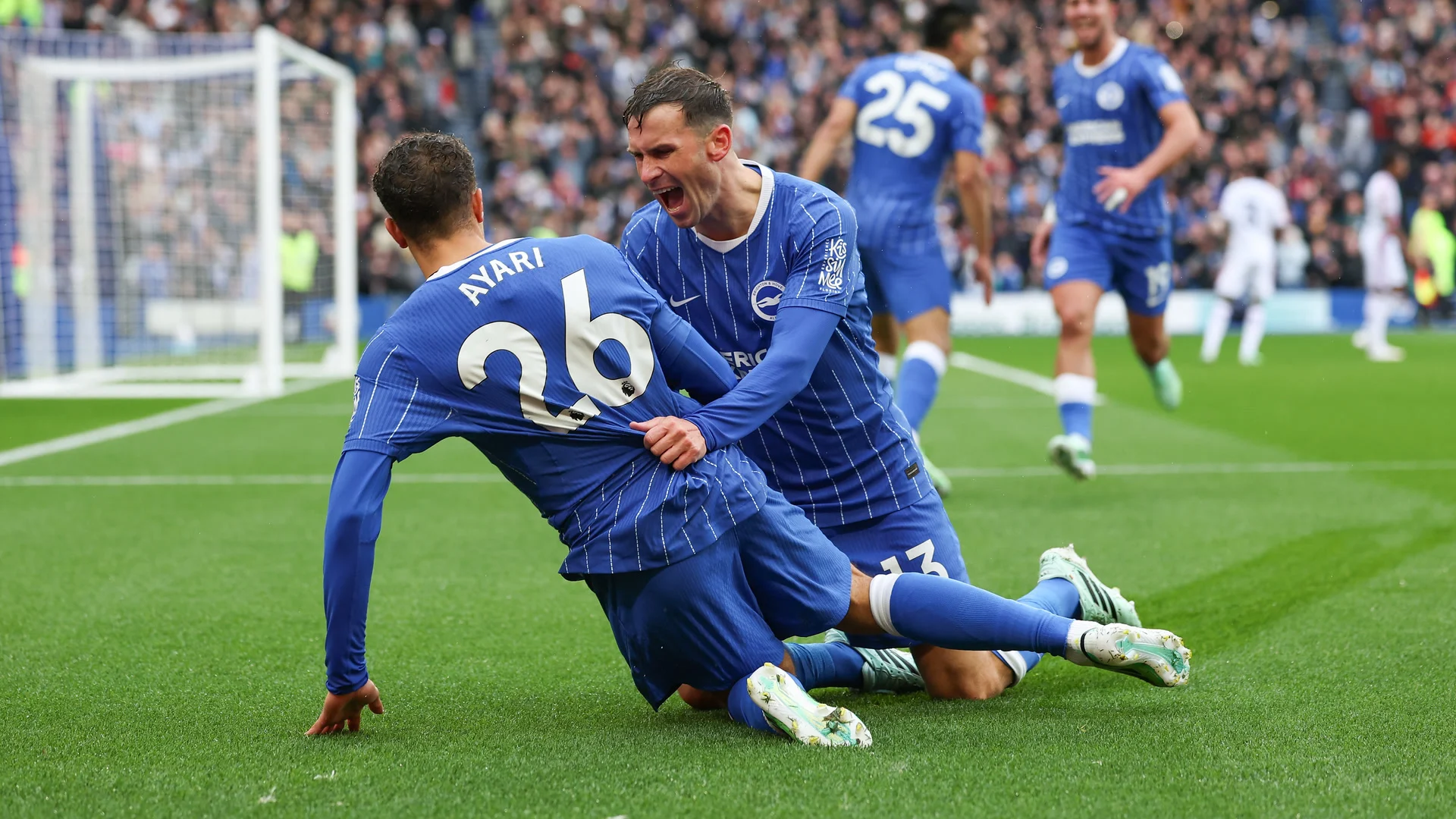 Brighton's Yasin Ayari, wearing number 26, slides on his knees in celebration as Pascal Gross, number 13, grabs him from behind after his goal made it 3-0 against Crystal Palace at the American Express Stadium. Photo: James Boardman/Brighton & Hove Albion