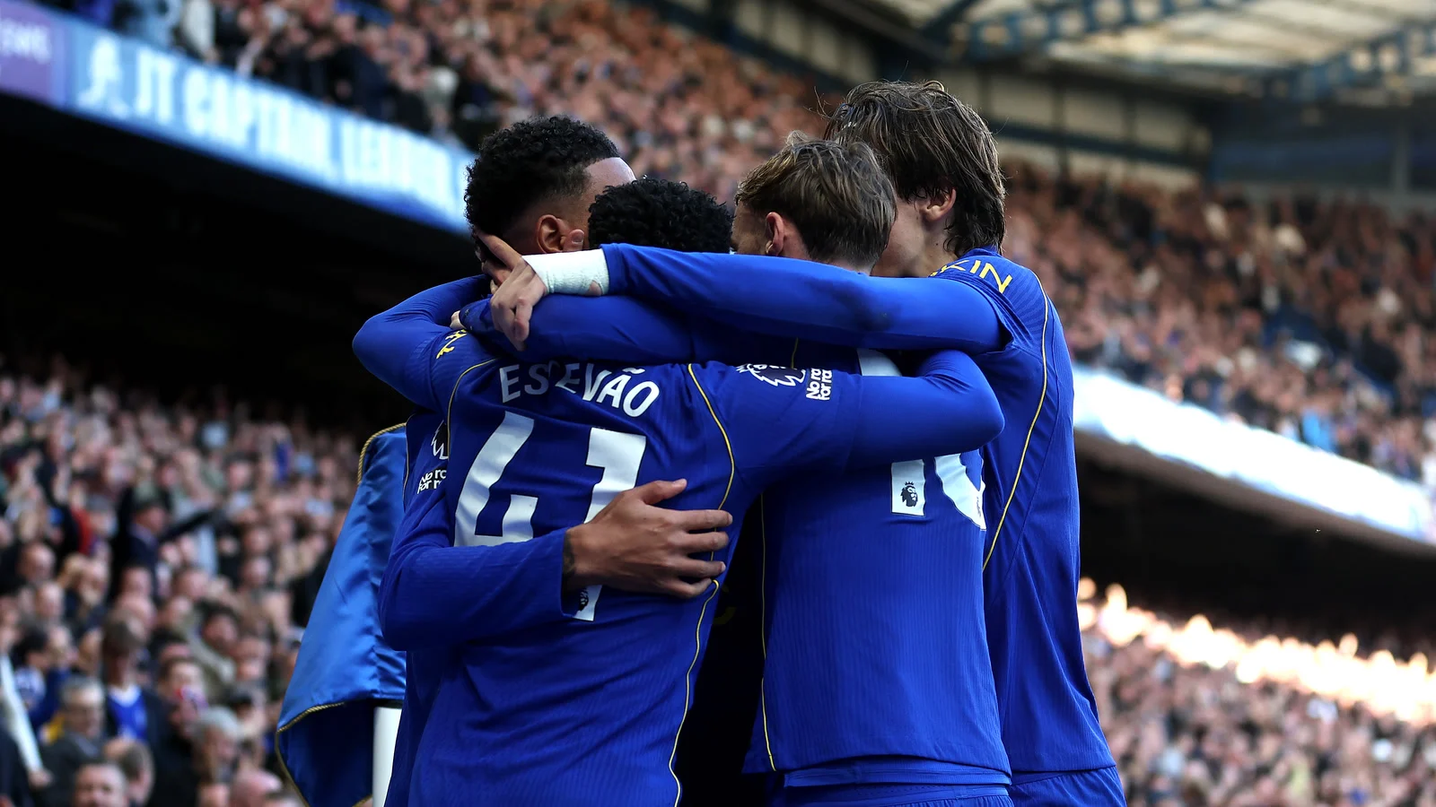 Chelsea players, seen from behind with Estêvão's name and number 41 on his shirt, celebrate Morgan Rogers' opening goal against Manchester United at Stamford Bridge