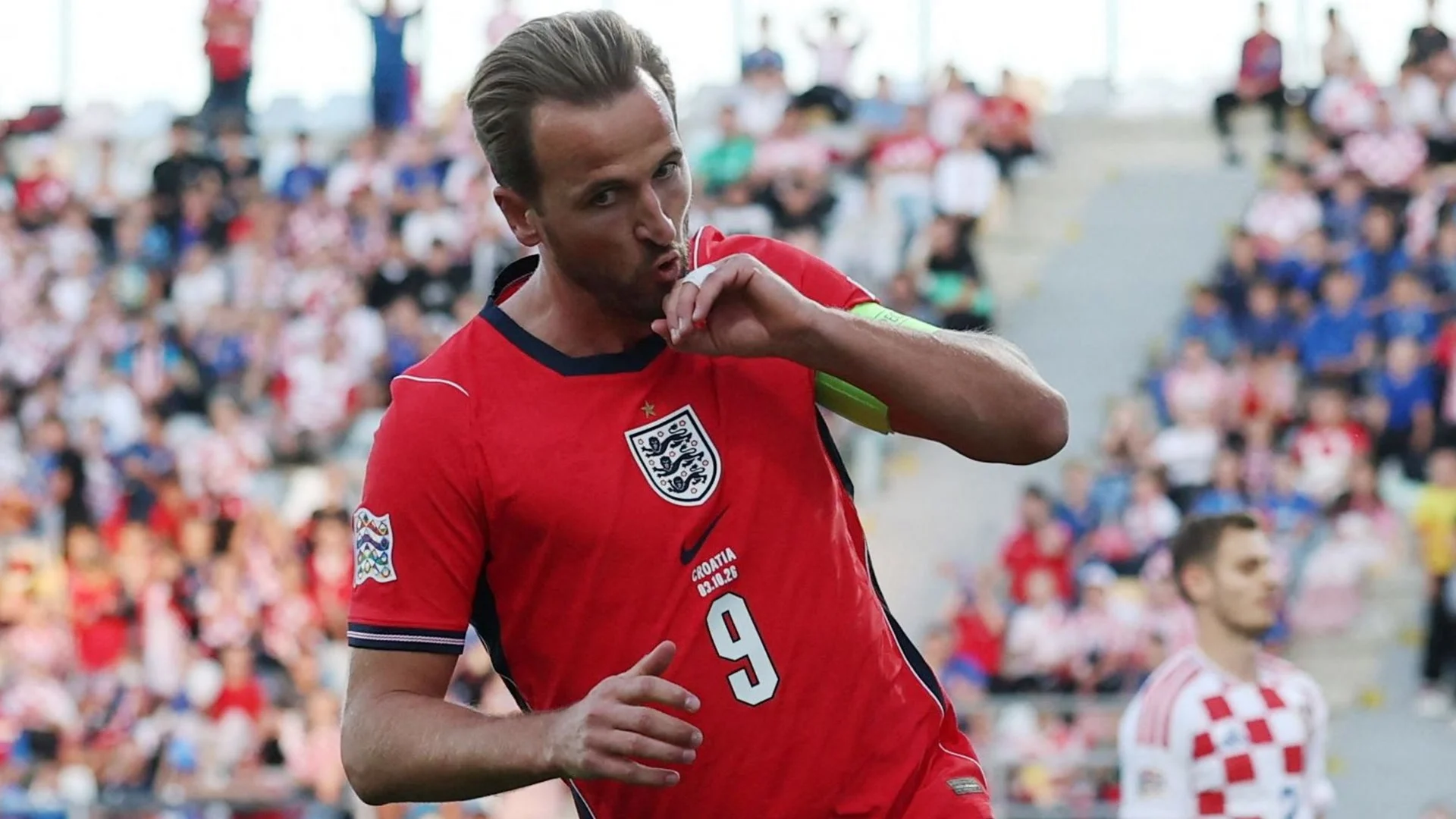 Harry Kane kisses his hand in celebration after opening the scoring for England against Croatia in Rijeka, wearing the red England shirt and captain's armband (Photo: Reuters via BBC Sport)