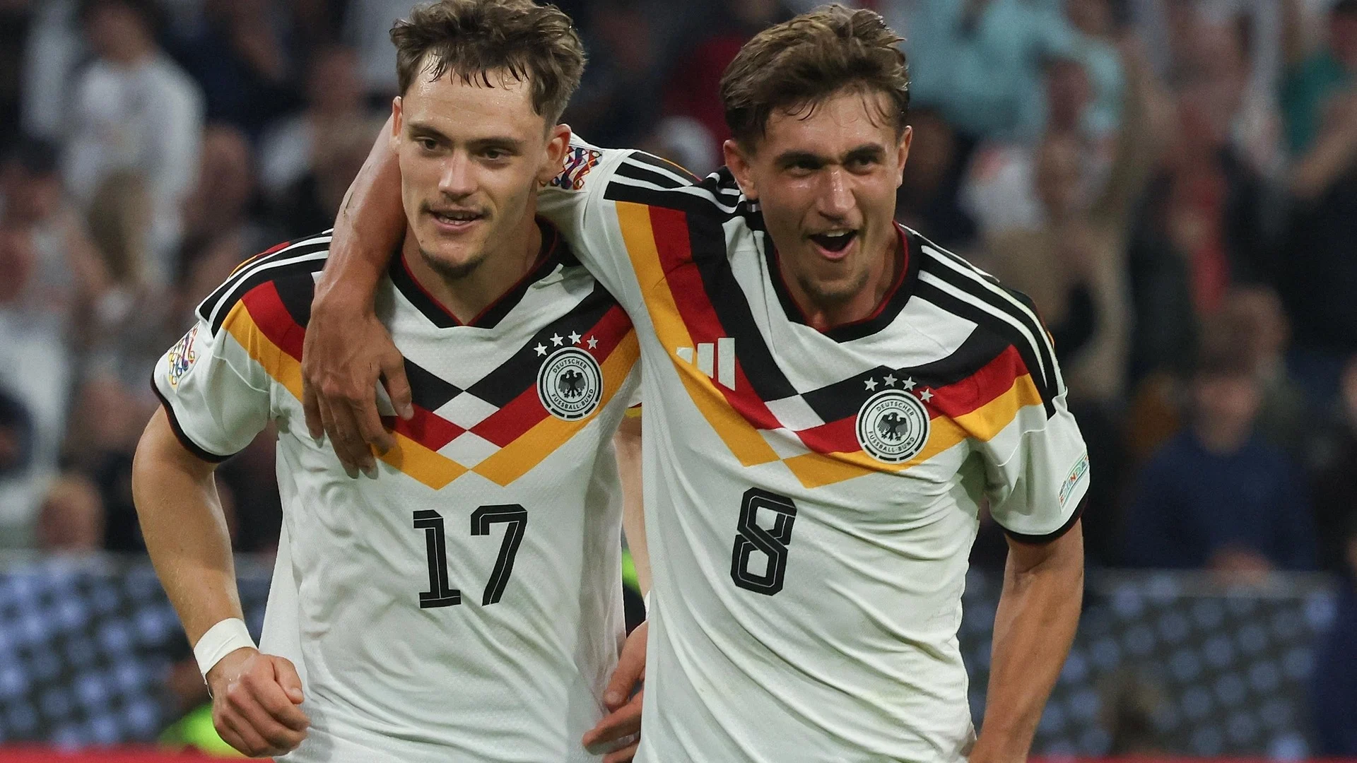 Florian Wirtz and Tom Bischof in Germany national-team shirts celebrating during the Nations League match against Serbia