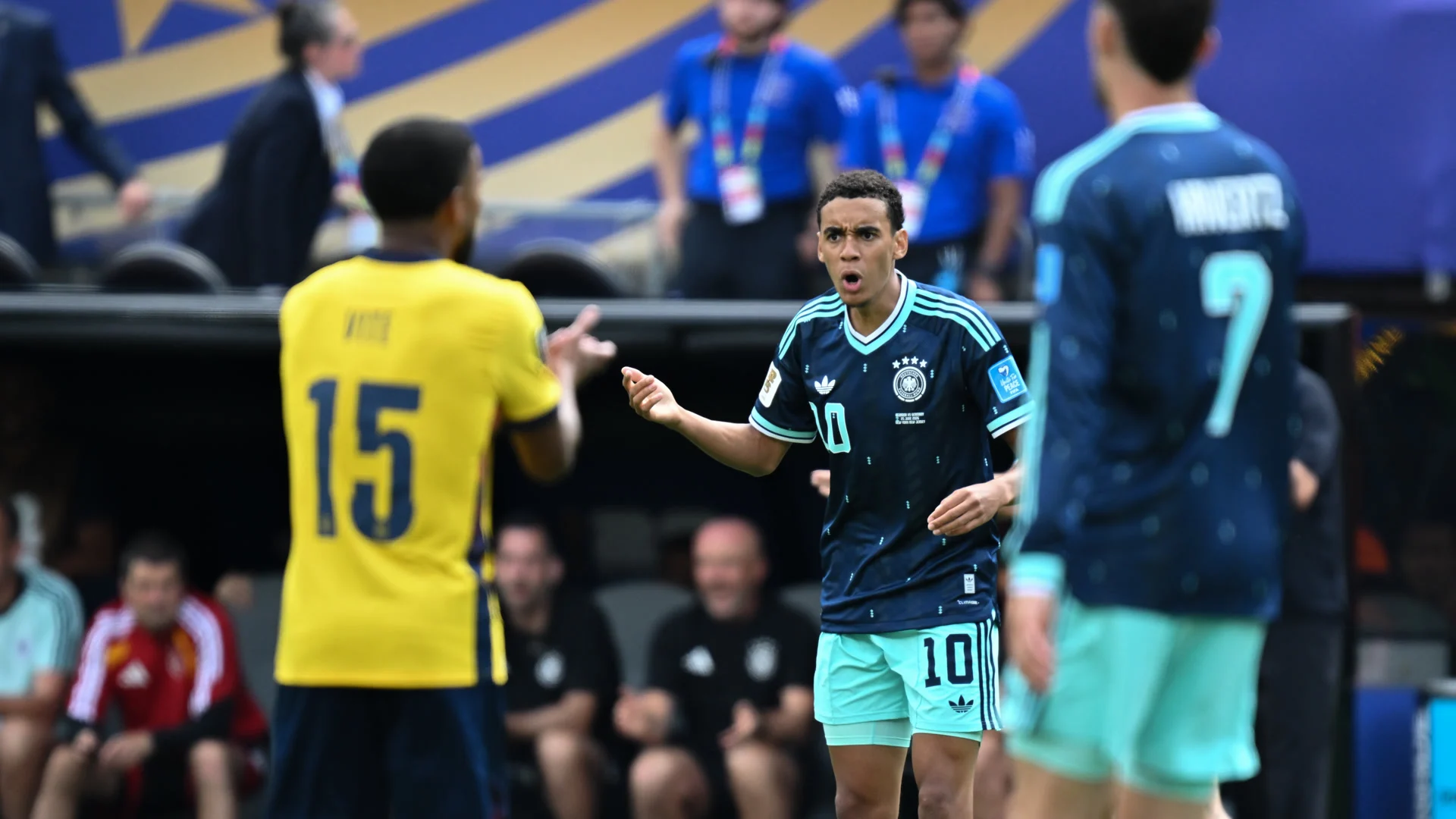 Jamal Musiala in a dark navy Germany number 10 kit gesturing during Ecuador vs Germany at the 2026 FIFA World Cup, with Kai Havertz visible behind him