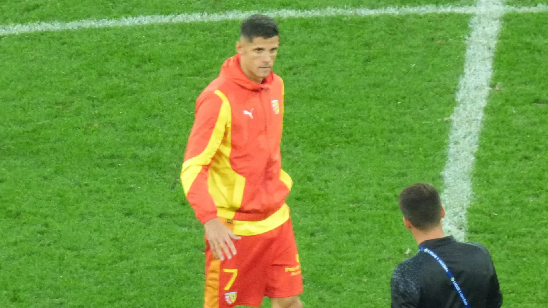 Florian Sotoca of RC Lens in a red and yellow warm-up kit with the number 7 on his shorts