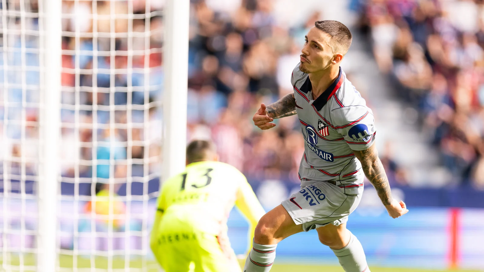 Álex Grimaldo turns away after scoring for Atlético Madrid in their grey away kit as Levante goalkeeper Mathew Ryan kneels by the post at the Ciutat de València