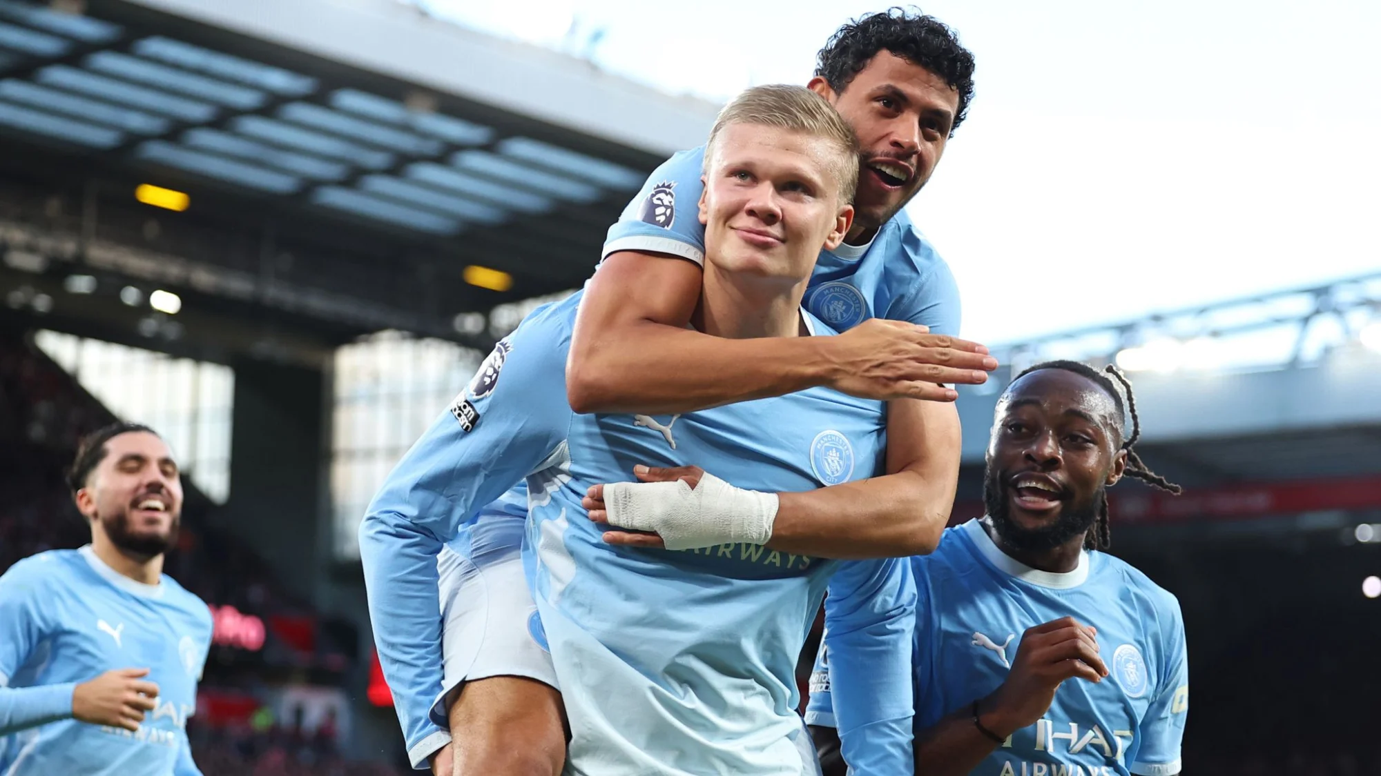 Erling Haaland celebrates on Matheus Nunes' shoulders with Jérémy Doku after scoring for Manchester City at Anfield. Photo: Sky Sports