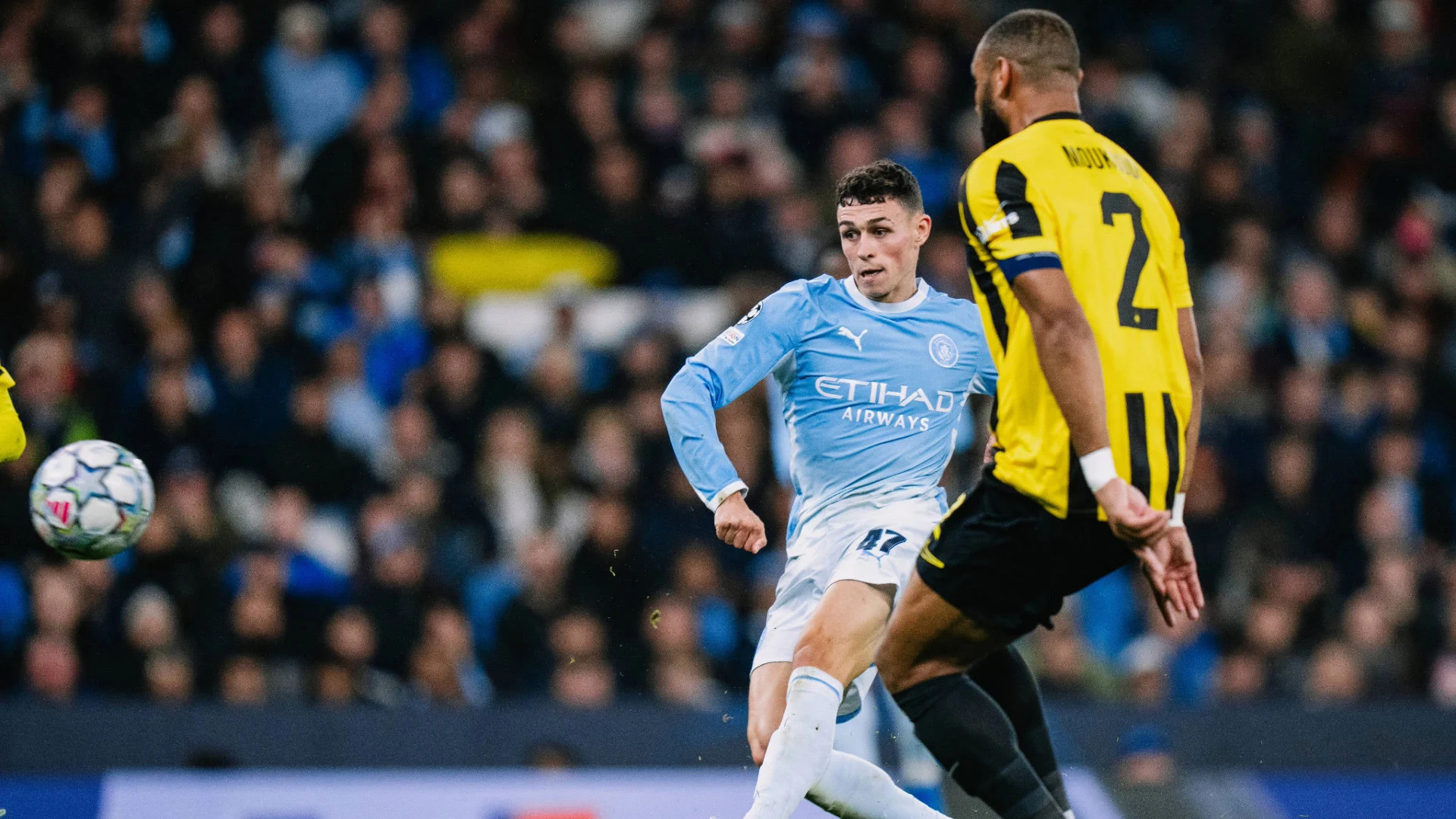 Phil Foden, in Manchester City's sky-blue home kit with number 47, shoots past AEK Athens captain Harold Moukoudi in yellow and black for his second goal against AEK Athens at the Etihad Stadium. Photo: Manchester City FC