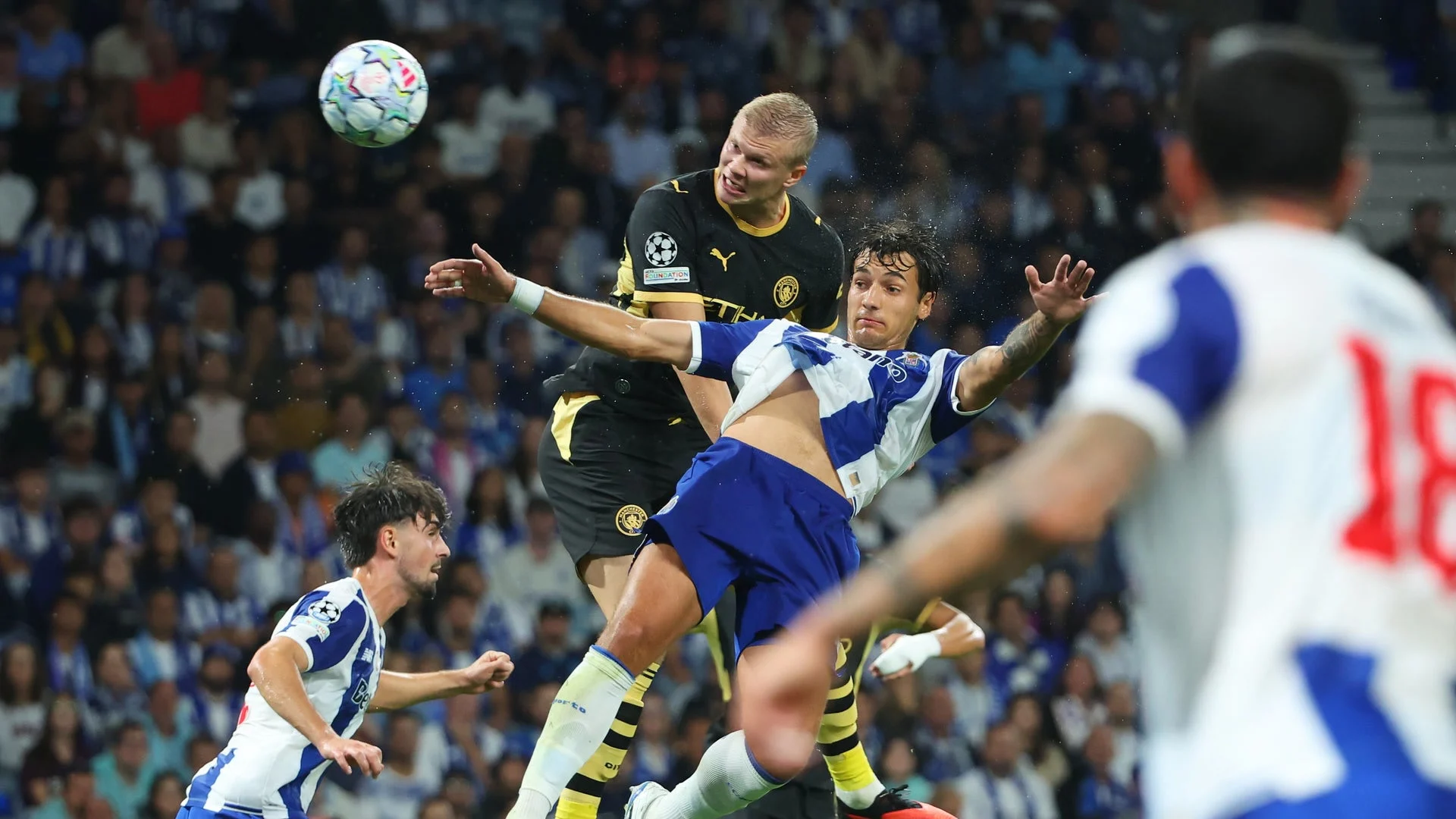 Erling Haaland in Manchester City's black away kit rises for a header against Porto in the Champions League.