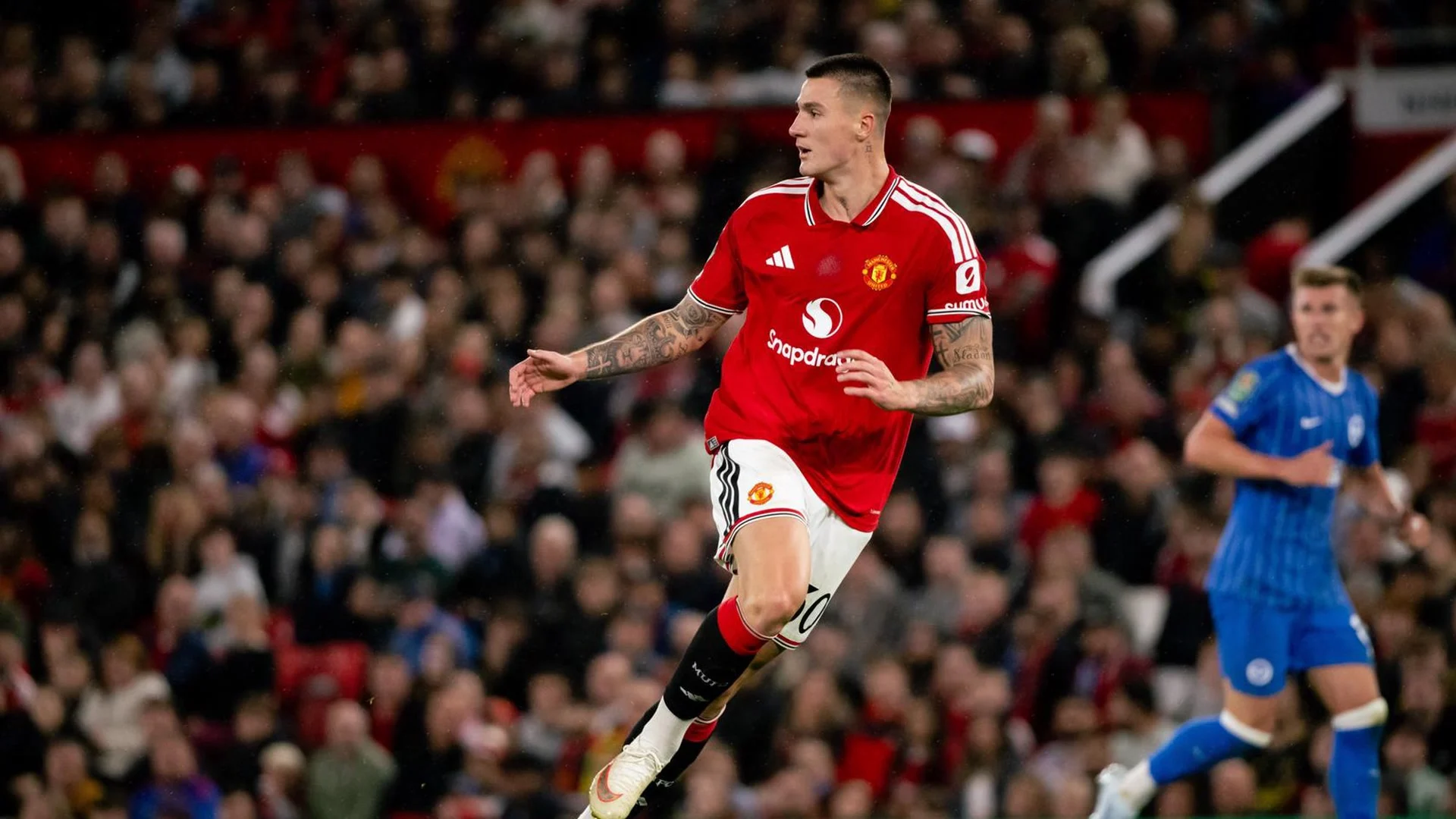 Benjamin Šeško running in Manchester United's red home kit during a match at Old Trafford