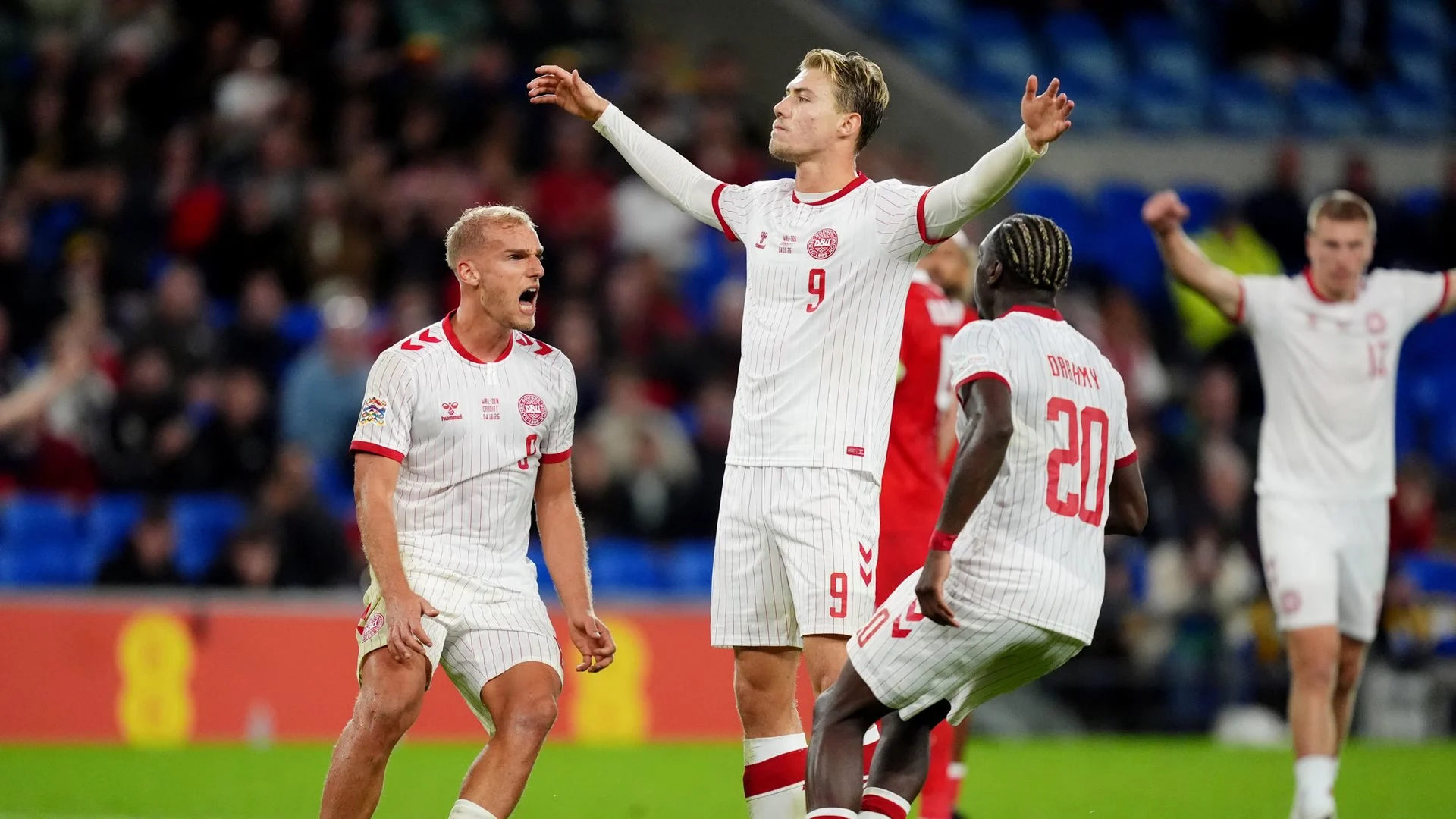 Denmark striker Rasmus Højlund celebrates with his arms outstretched in Denmark's white kit after scoring a penalty against Wales at Cardiff City Stadium (Photo: PA via WalesOnline)