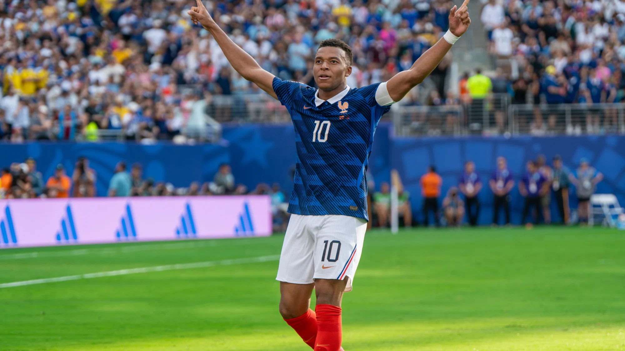 Kylian Mbappé in France number 10 kit celebrating with both arms raised during a 2026 World Cup match