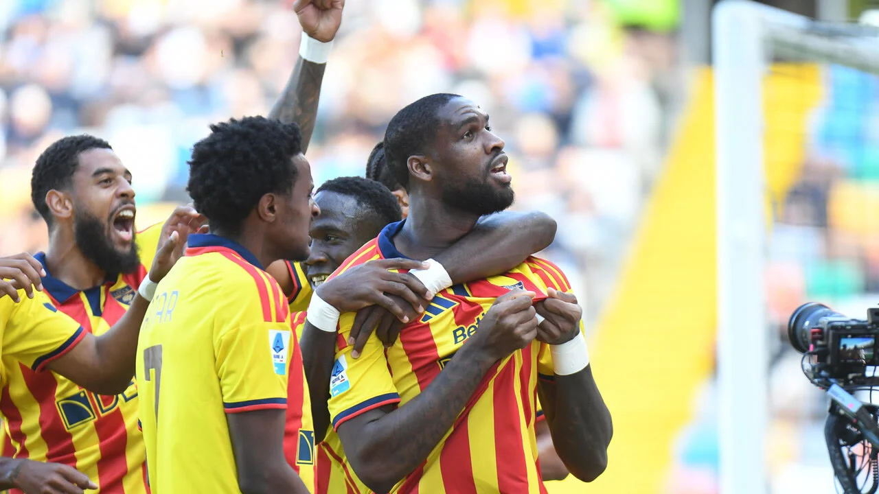 Lecce players in their red and yellow striped kit celebrate together after scoring against Udinese at the Bluenergy Stadium in Udine. Photo: ANSA