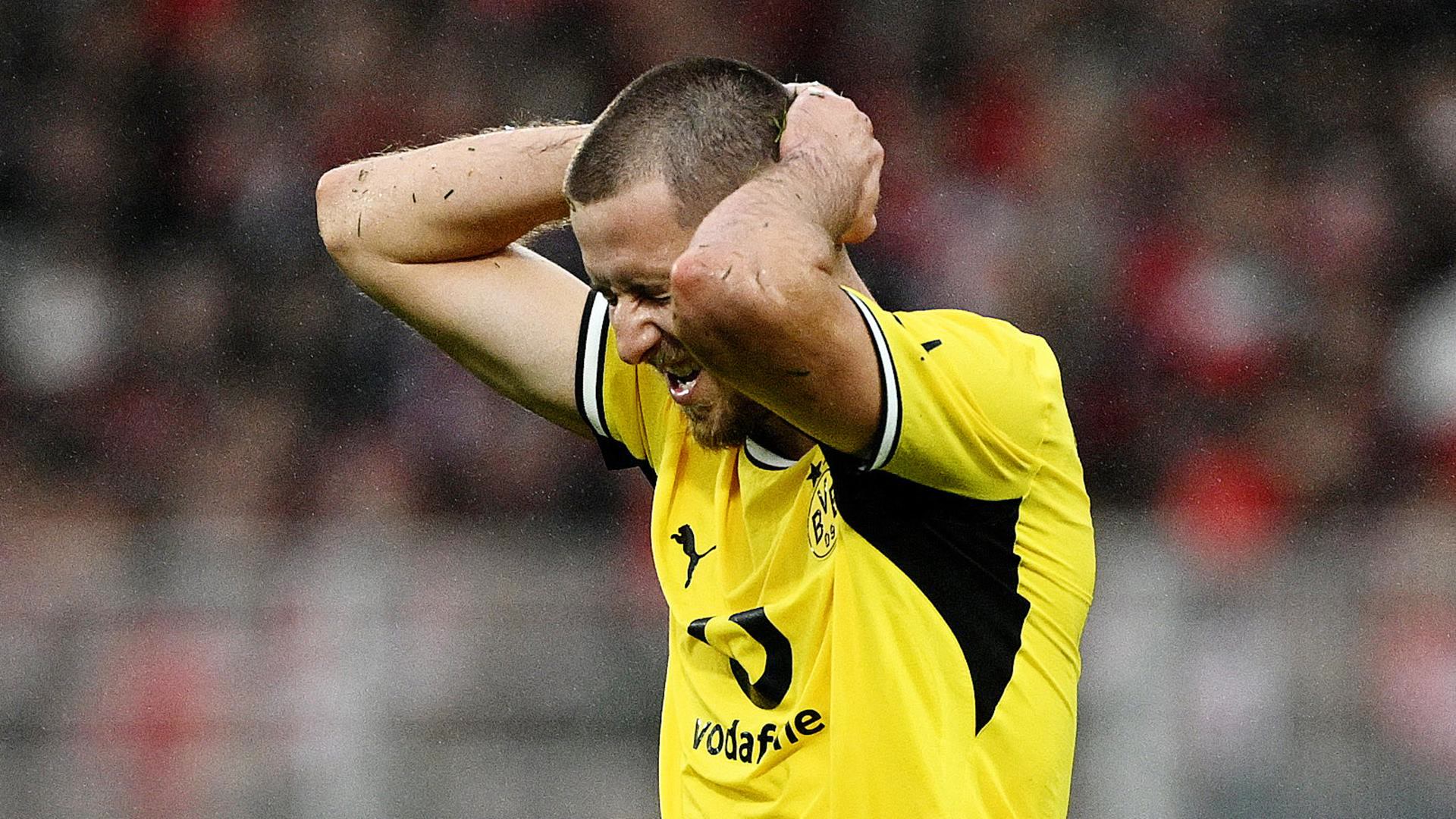 Dortmund defender Waldemar Anton, in Borussia Dortmund's yellow kit and wet from the rain, holds both hands behind his head in frustration during the 0-0 draw at Union Berlin. Photo: Reuters